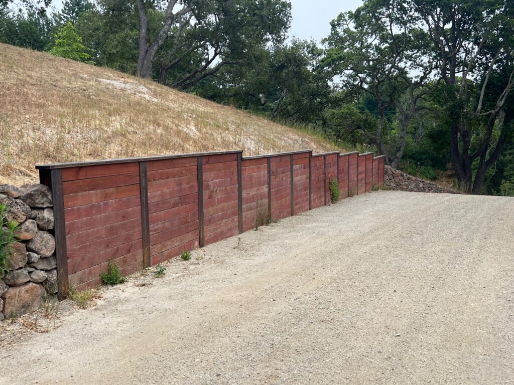 A photo of a wood retaining wall designed and installed by The Landscape Company.