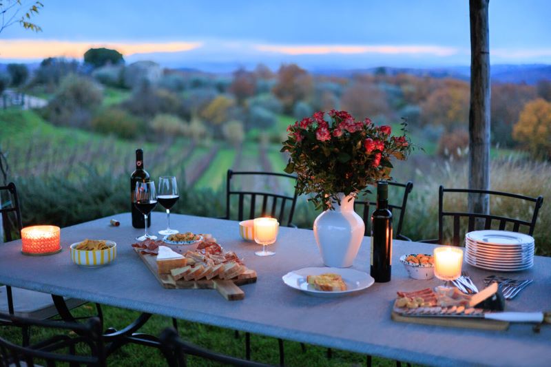A photo of an outdoor dining table next to a field.