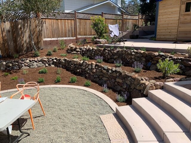 A custom landscape design with rock walls and gardens by The Landscape Company.