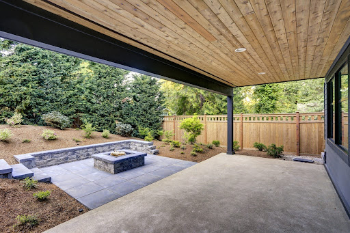 A photo of a landscaped property with a patio and gardens with mulch.