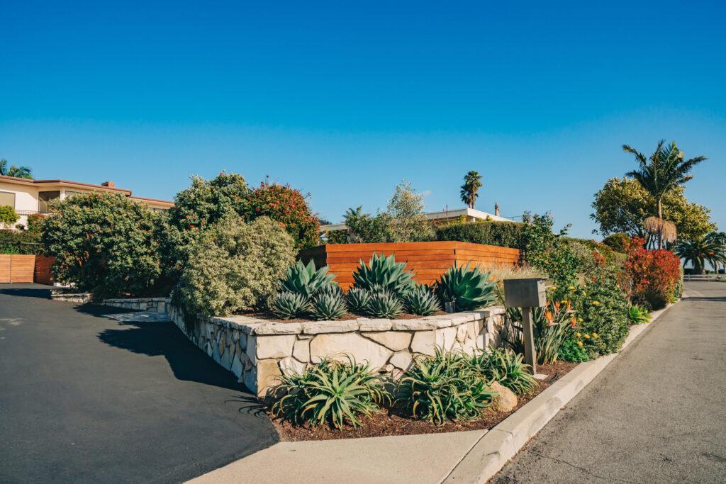 Houses with beautifully landscaped front yards on a sunny day.