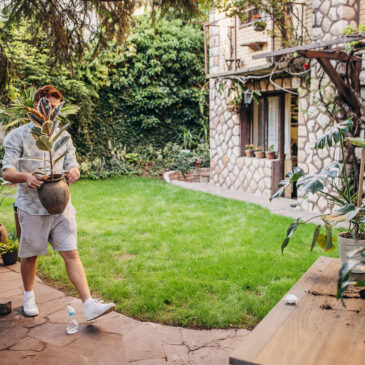 One man taking care of his plants in back yard of his home.